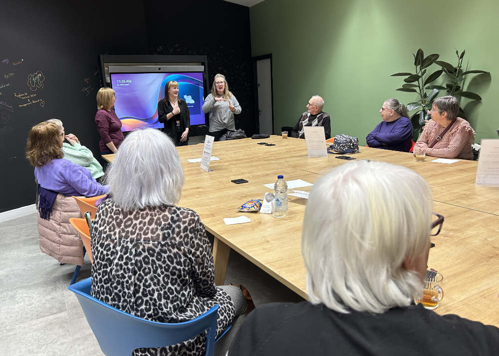 A group of people sitting around a wooden table.