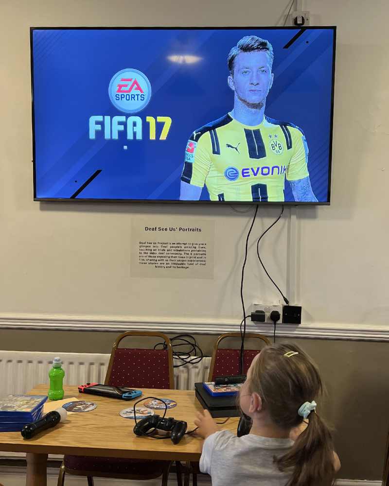 A young girl playing a video game on a tv.