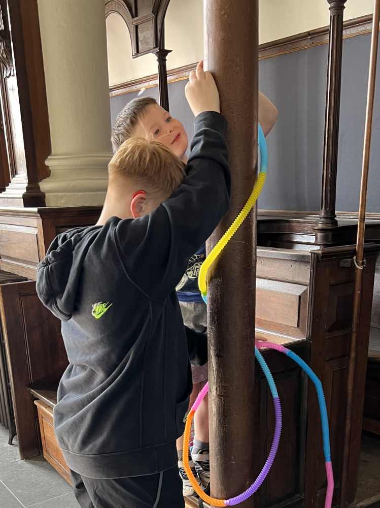 Two boys playing with colorful hula hoops in a church.