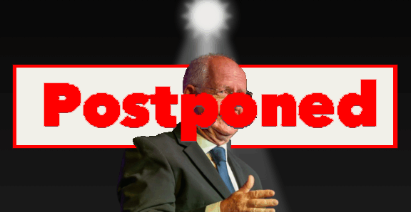 A man in a suit gesturing, with the word "Postponed" in bold red letters covering him and a spotlight shining from above.